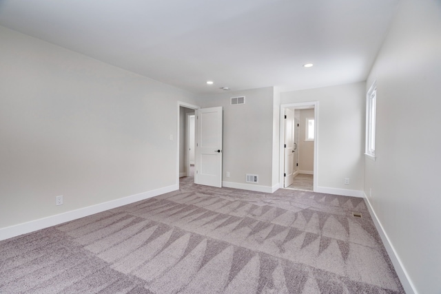 unfurnished bedroom featuring recessed lighting, baseboards, visible vents, and light colored carpet