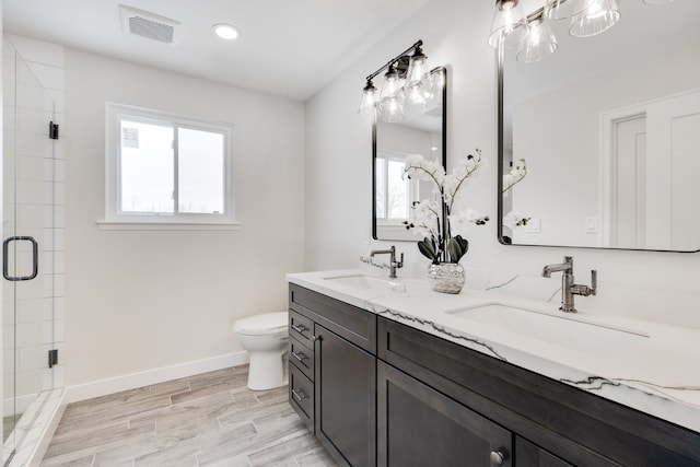 full bathroom with baseboards, visible vents, a sink, and wood finished floors