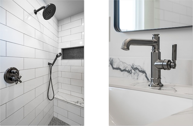 bathroom featuring a tile shower and a sink