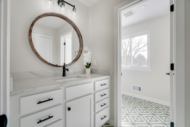 bathroom with vanity, visible vents, and baseboards