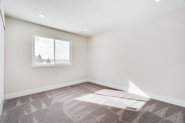 carpeted empty room featuring recessed lighting and baseboards