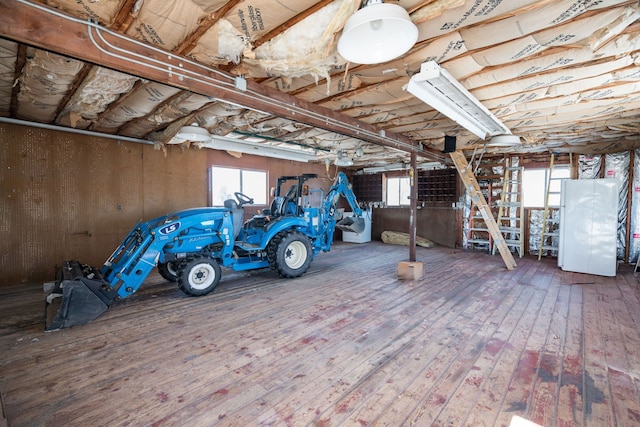 below grade area featuring wood finished floors and freestanding refrigerator