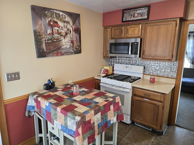 kitchen with decorative backsplash and white range with gas stovetop