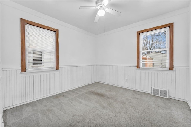 carpeted spare room featuring ceiling fan