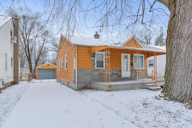 bungalow featuring a garage, an outbuilding, and a porch