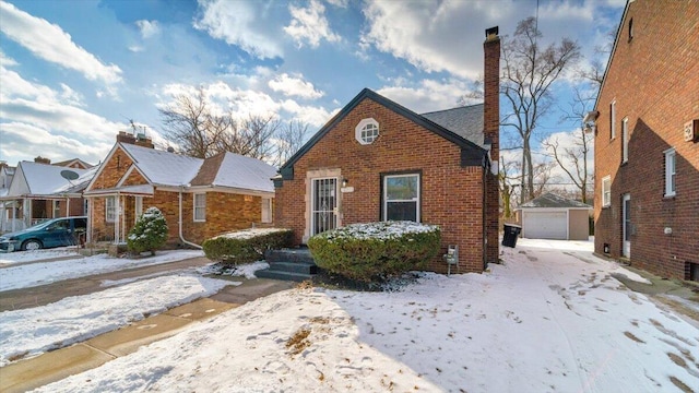 view of front of home with a garage and an outbuilding