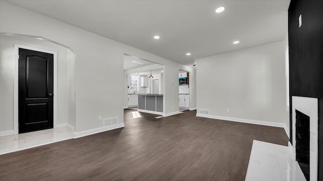 unfurnished living room with a fireplace and dark hardwood / wood-style flooring