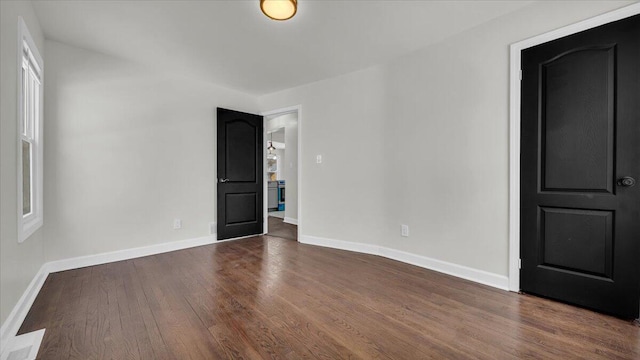 spare room with dark wood-type flooring