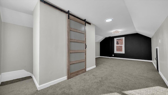 bonus room with a barn door, carpet floors, and lofted ceiling