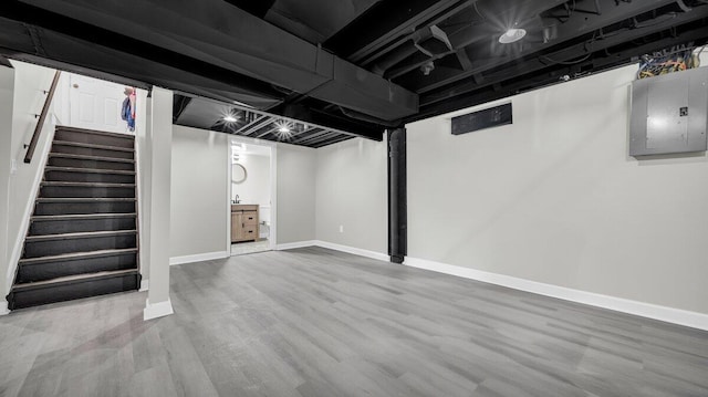 basement with wood-type flooring and electric panel