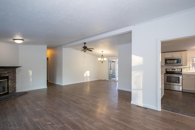 unfurnished living room with dark wood-type flooring, ceiling fan with notable chandelier, a textured ceiling, and a fireplace