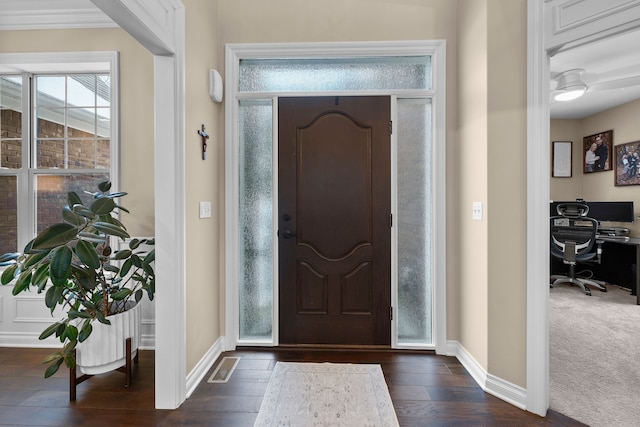 entrance foyer with dark wood-type flooring, visible vents, and baseboards