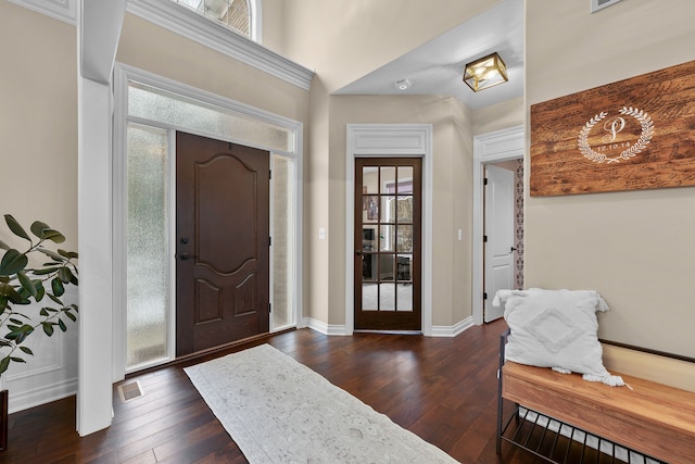 foyer featuring visible vents, baseboards, and dark wood-type flooring