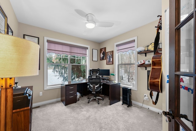 office featuring baseboards, ceiling fan, and light colored carpet