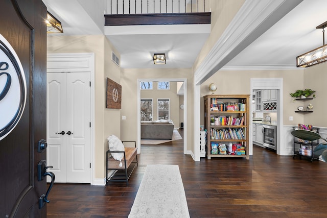 entrance foyer with ornamental molding, wine cooler, dark wood-style flooring, and visible vents