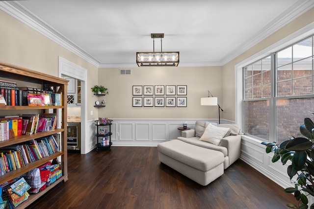 sitting room featuring ornamental molding, a wainscoted wall, visible vents, and dark wood finished floors