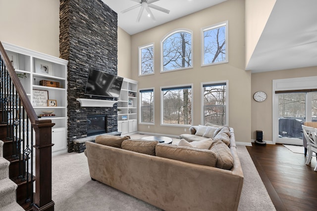 living area with plenty of natural light, stairs, and a fireplace