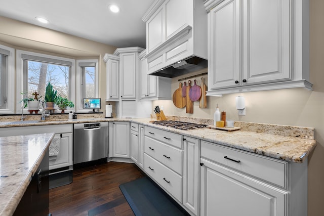 kitchen featuring stainless steel appliances, a sink, white cabinetry, and light stone countertops