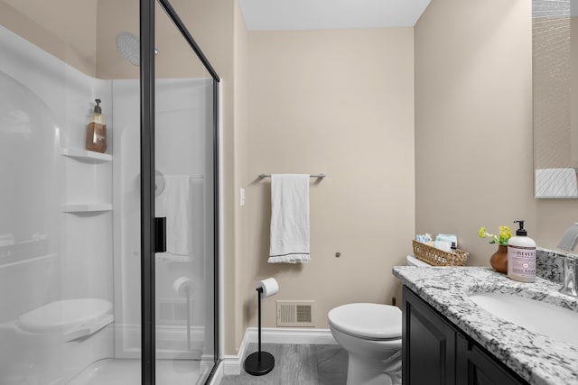 full bath featuring a stall shower, baseboards, visible vents, toilet, and vanity