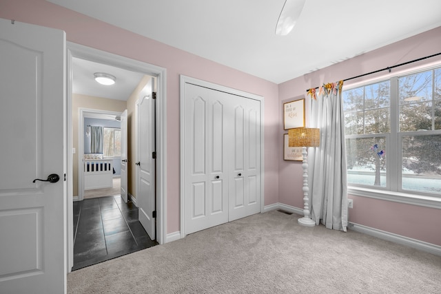 bedroom featuring a closet, dark carpet, and baseboards