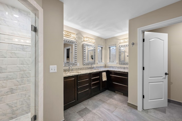 bathroom featuring double vanity, a shower stall, and a sink