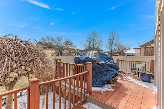 snow covered deck with a grill