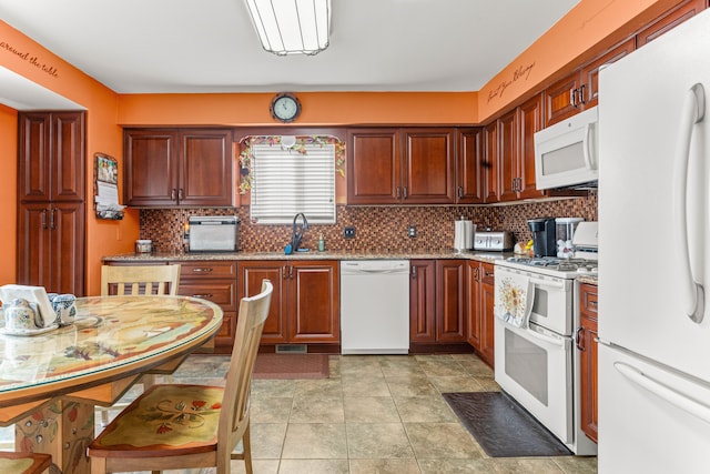 kitchen featuring sink, light stone counters, light tile patterned floors, white appliances, and backsplash