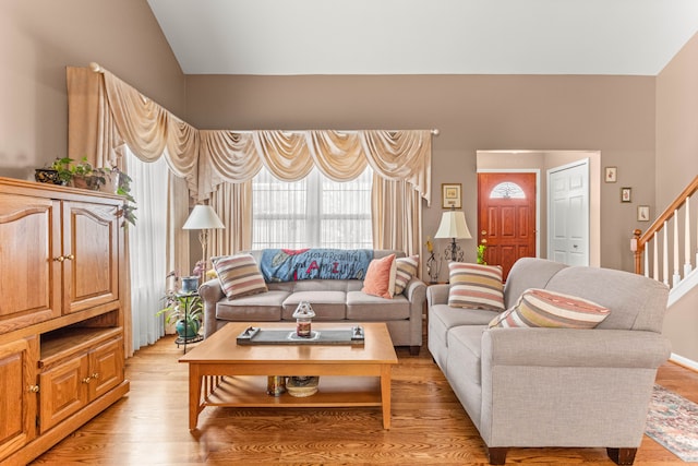 living room featuring lofted ceiling and light wood-type flooring