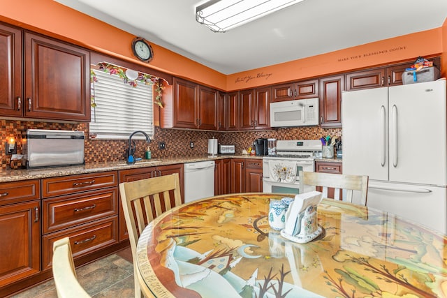 kitchen with sink, white appliances, light stone countertops, and decorative backsplash