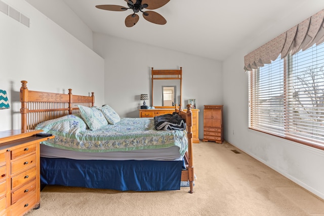 bedroom with vaulted ceiling, light colored carpet, and ceiling fan