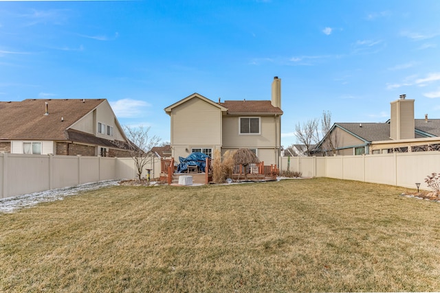 back of property featuring a wooden deck and a yard