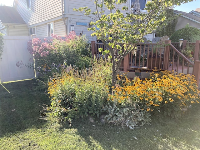 exterior space featuring a wooden deck and a lawn