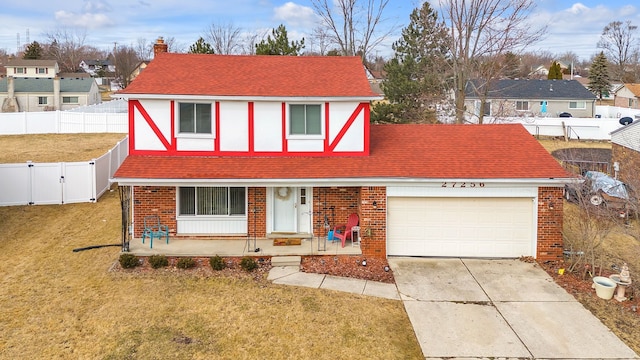 view of front facade with driveway, a porch, an attached garage, a fenced backyard, and a chimney