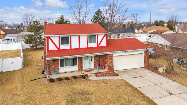 view of front of house with a front yard, a gate, driveway, a chimney, and a garage