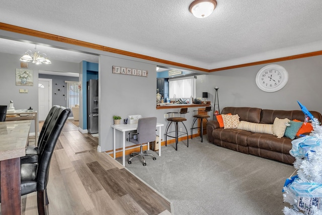 living area featuring baseboards, a textured ceiling, an inviting chandelier, and wood finished floors