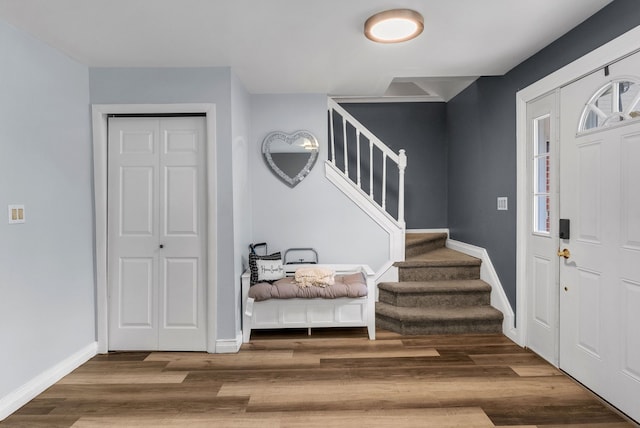 entryway featuring stairs, wood finished floors, and baseboards