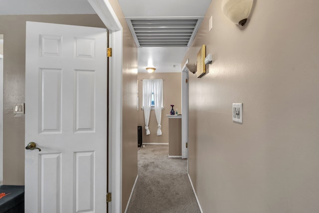 hallway featuring visible vents, baseboards, and carpet floors