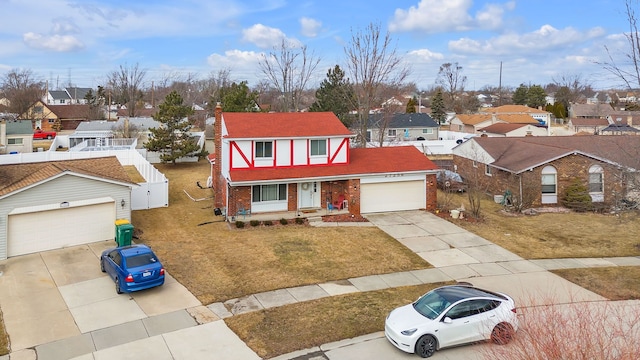 view of front facade featuring an attached garage, a residential view, concrete driveway, a front lawn, and brick siding