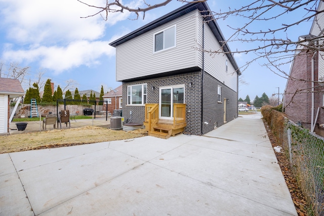 rear view of property with cooling unit and a patio area