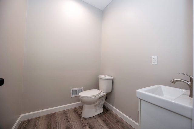 bathroom with wood-type flooring and toilet