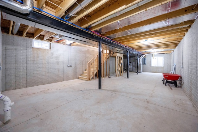 basement with a healthy amount of sunlight and brick wall