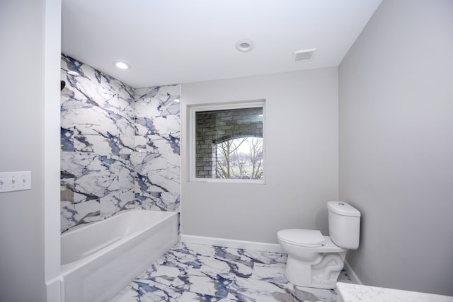 bathroom featuring tiled shower / bath and toilet