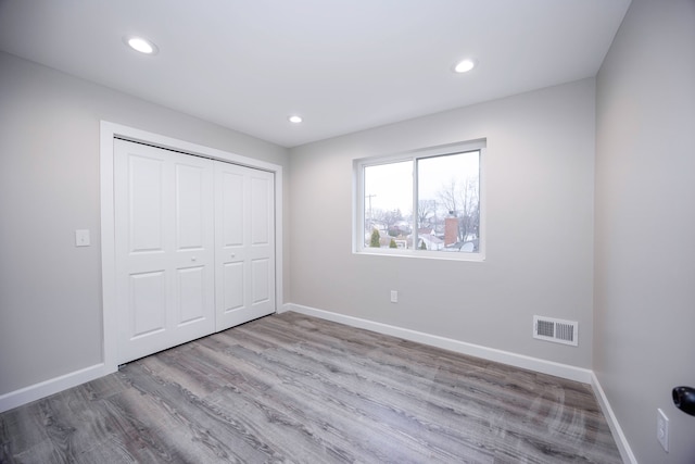 unfurnished bedroom with light hardwood / wood-style floors and a closet