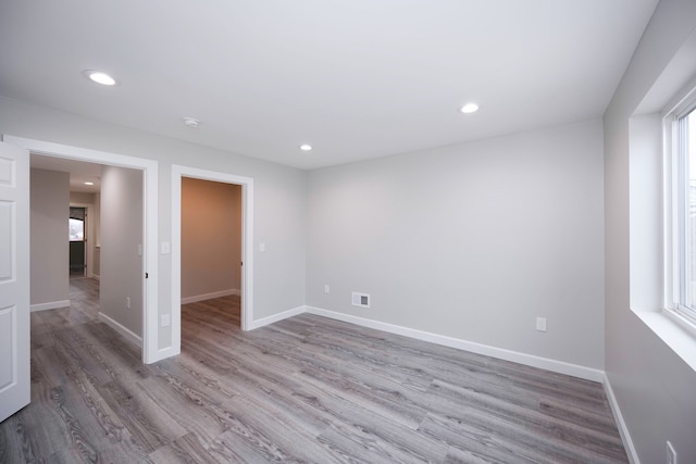 spare room featuring plenty of natural light and light hardwood / wood-style floors