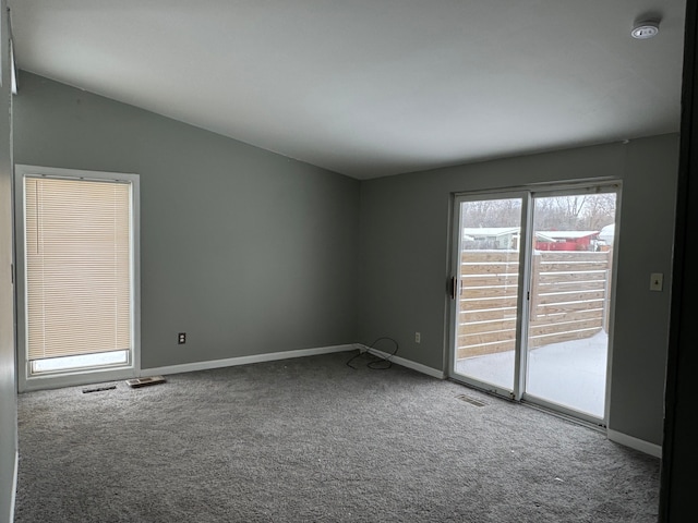 carpeted spare room with vaulted ceiling