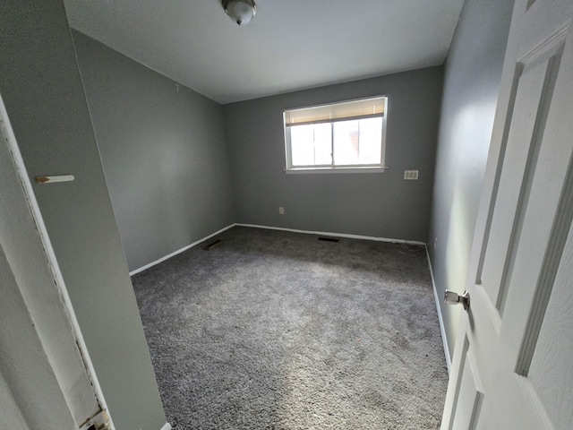 empty room featuring dark carpet