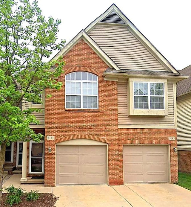 view of front of house featuring a garage, driveway, and brick siding