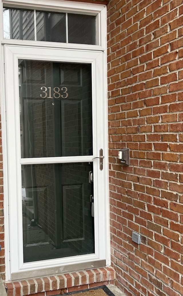 view of exterior entry featuring brick siding