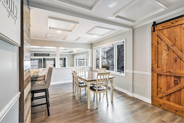 dining room with hardwood / wood-style flooring, crown molding, a barn door, and a healthy amount of sunlight