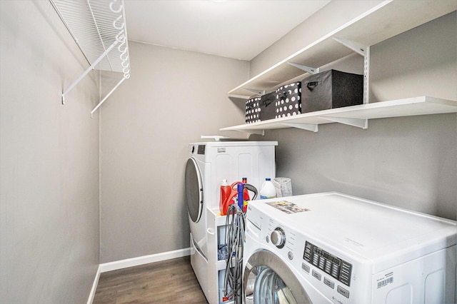 clothes washing area featuring dark wood-type flooring and washing machine and dryer